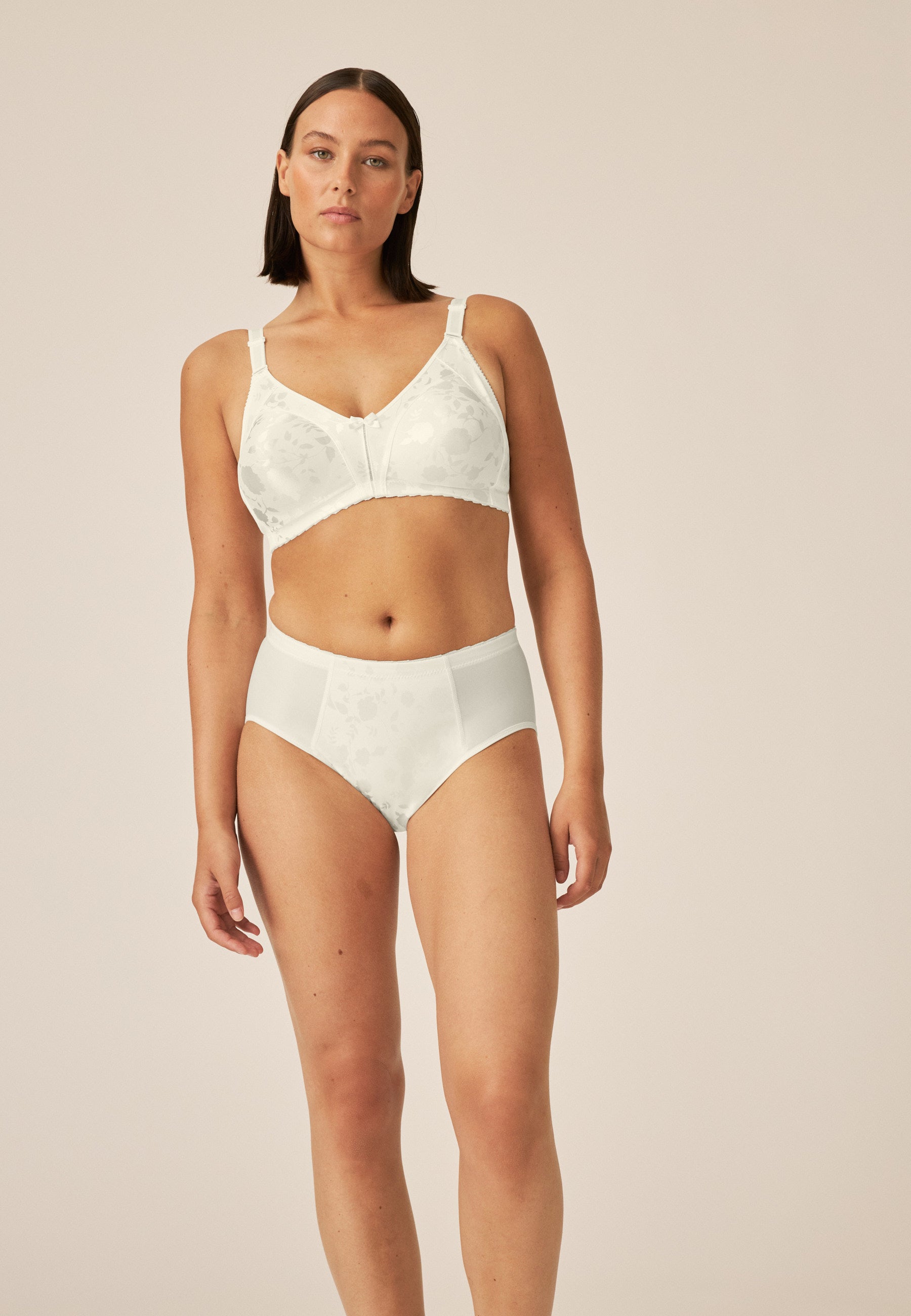 Model zeigt den Naturana Minimizer Slip mit Blumenmuster in der Farbe Champagner