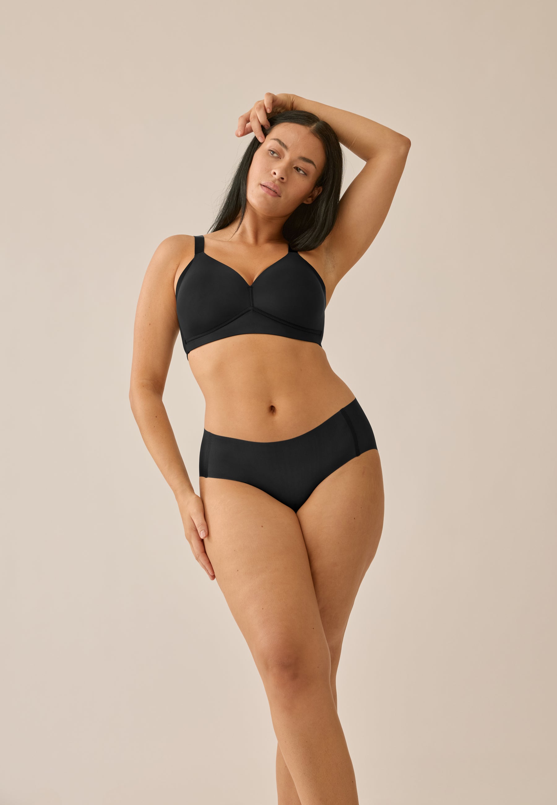 Model posiert in NATURANA Everyday Slip und BH in der Farbe schwarz, stehend in Frontansicht