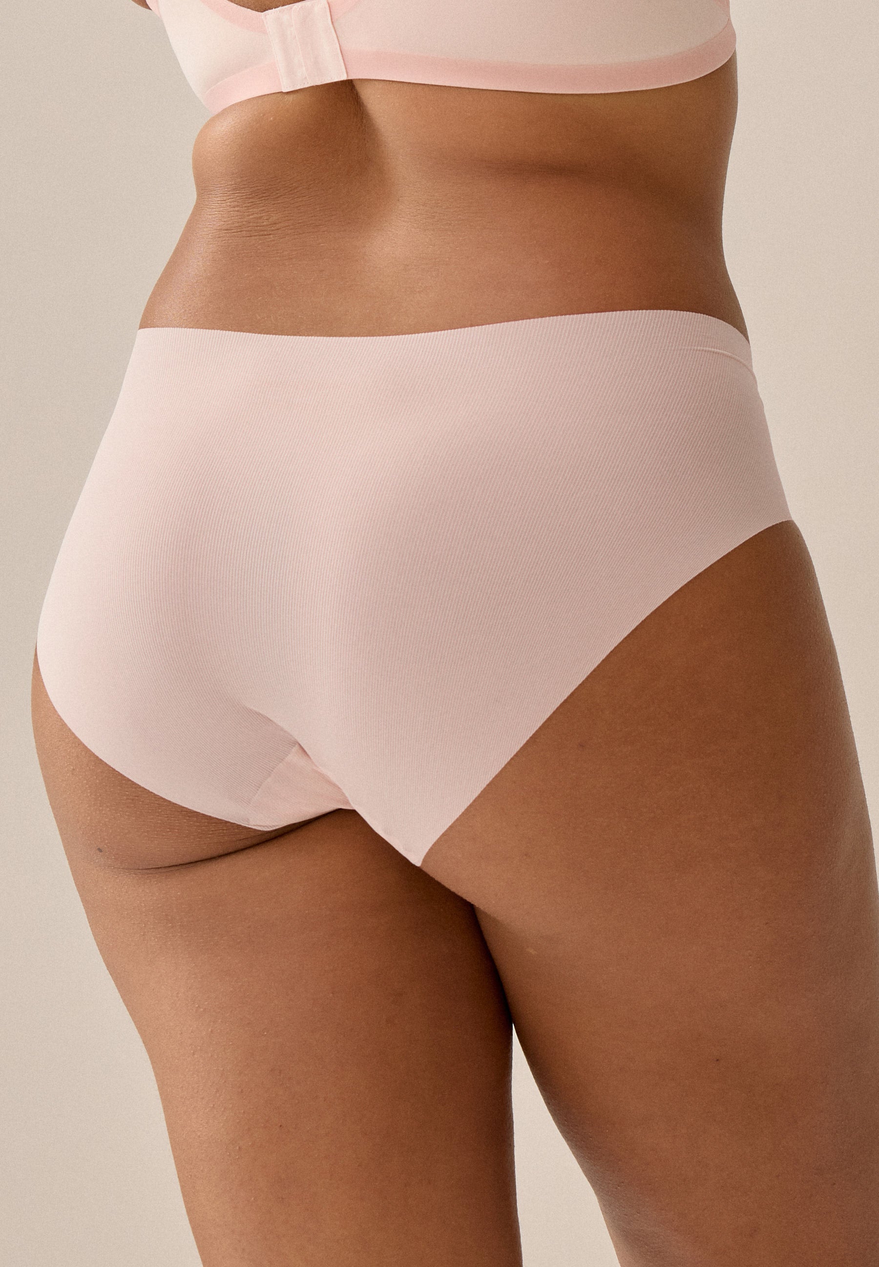 Das Model trägt das Naturana One Size Höschen in der Farbe Blush aus einem Winkel von hinten