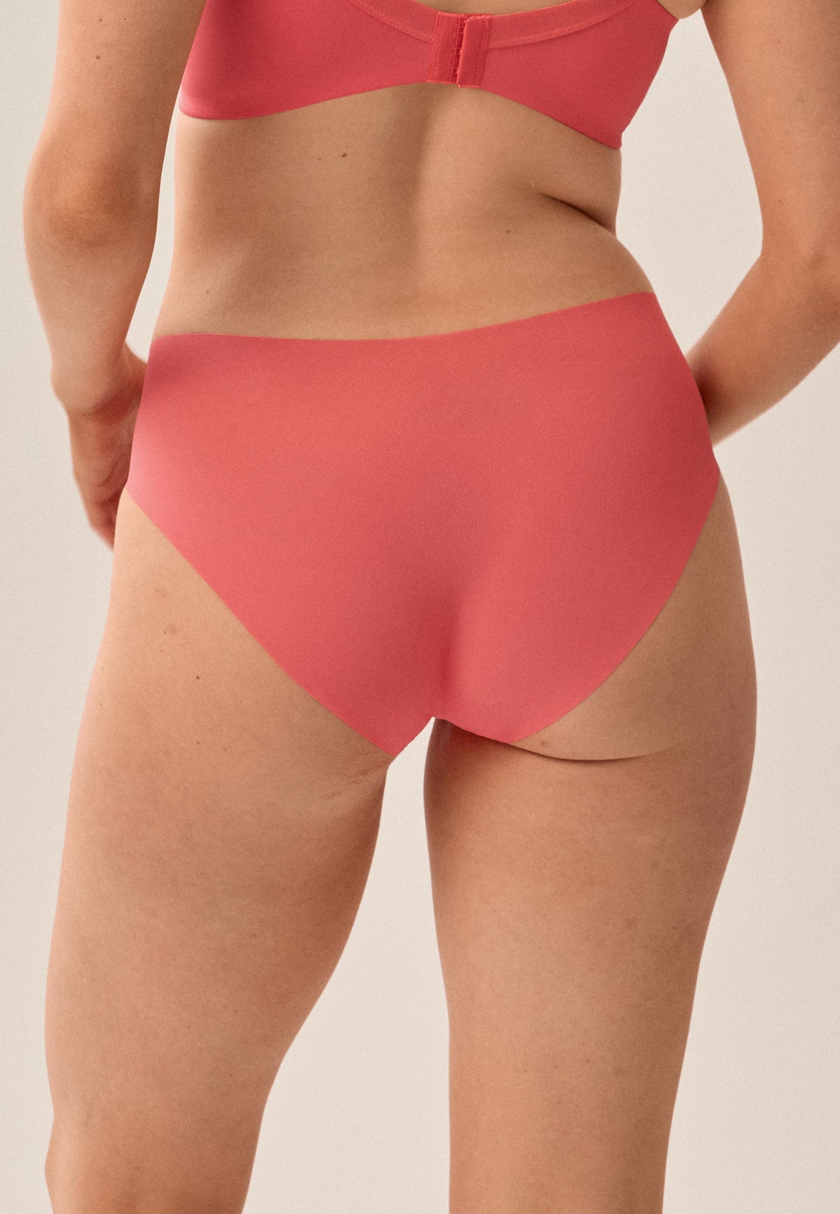 Korallpinke NATURANA One-Size-Panty mit passendem bügellosen Soft-BH, Model von hinten