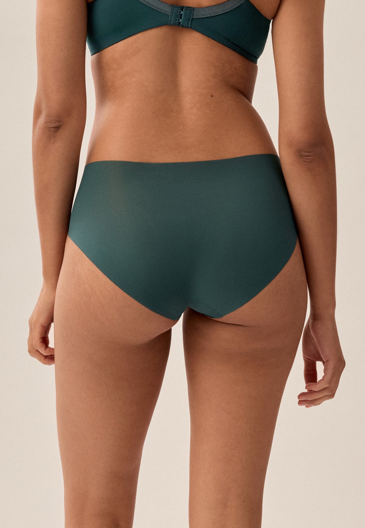 Tannengrüne NATURANA One-Size-Panty mit dehnbarem Bund und passendem BH, Model von hinten