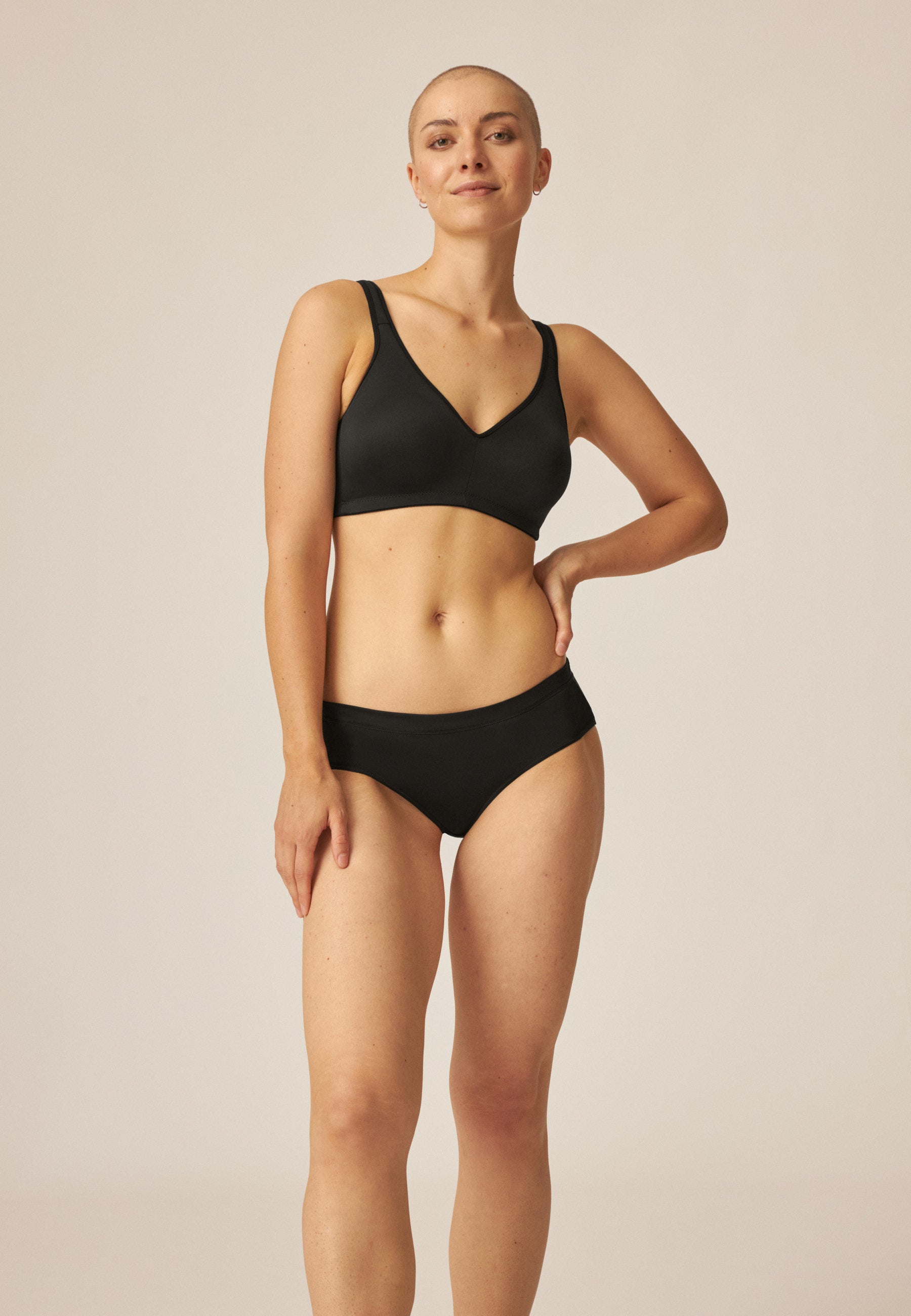 Model zeigt den Naturana Wednesday Softer Slip mit Glanzband in der Farbe Schwarz