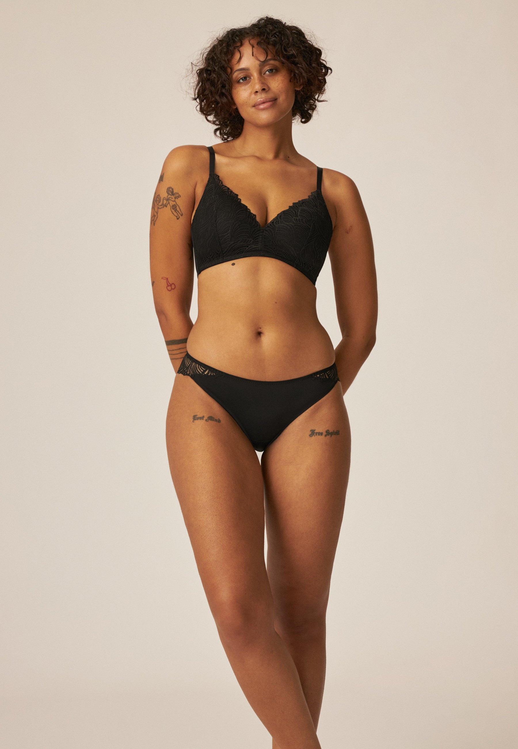 Model zeigt den Naturana Friday Slip mit Spitzendetails in der Farbe Schwarz