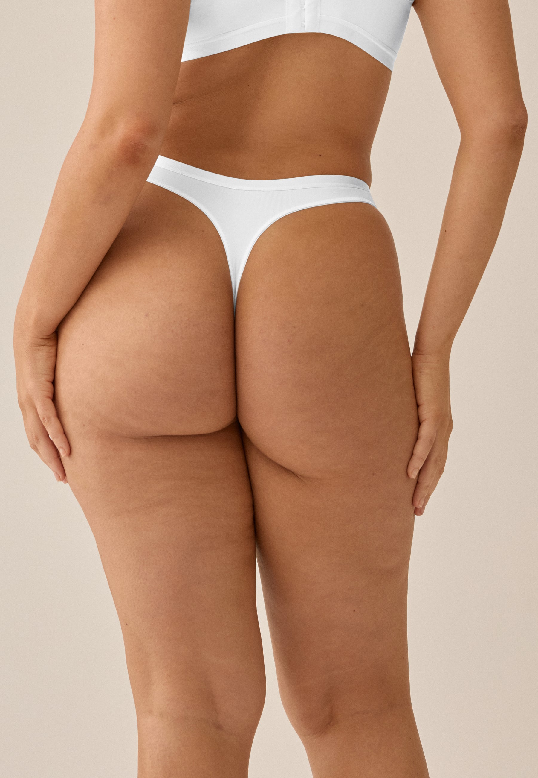 Model posiert in NATURANA BH mit Bügel und String in der Farbe weiß
