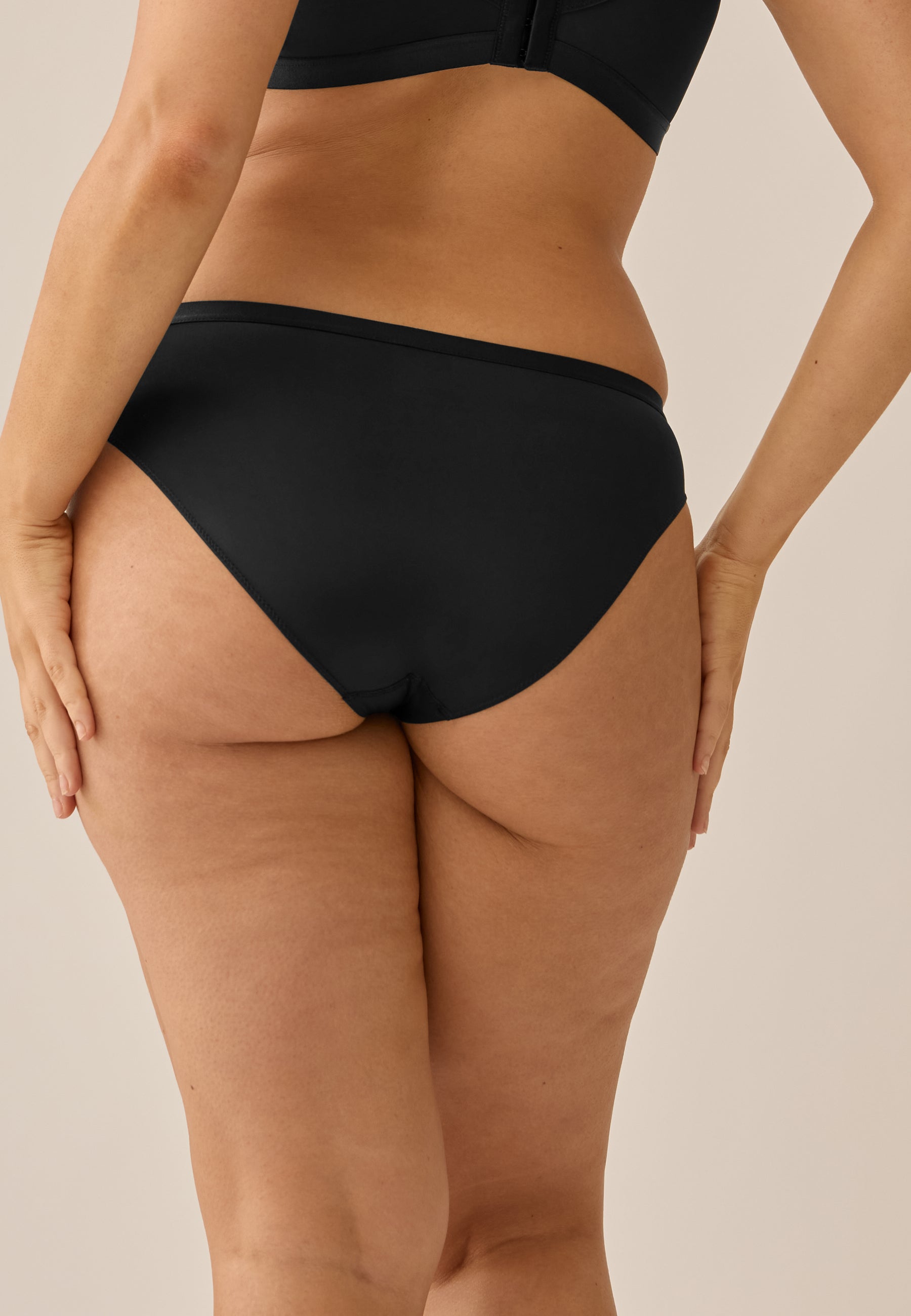 Model steht in NATURANA BH mit Bügel und Slip in der Farbe schwarz