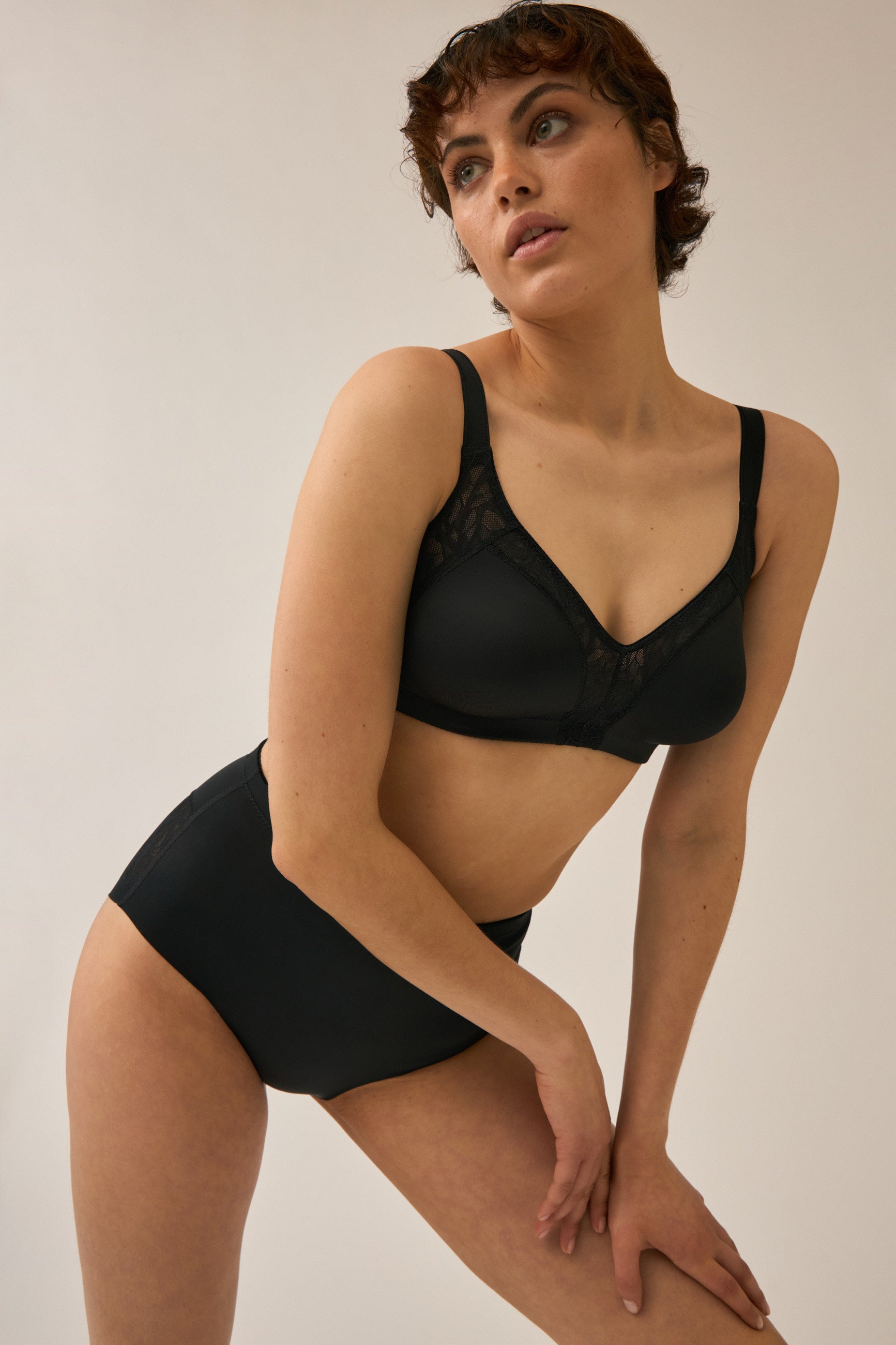 Model posiert im Naturana Minimizer und Side Smoother BH mit Spitze Farbe in der Farbe Schwarz
