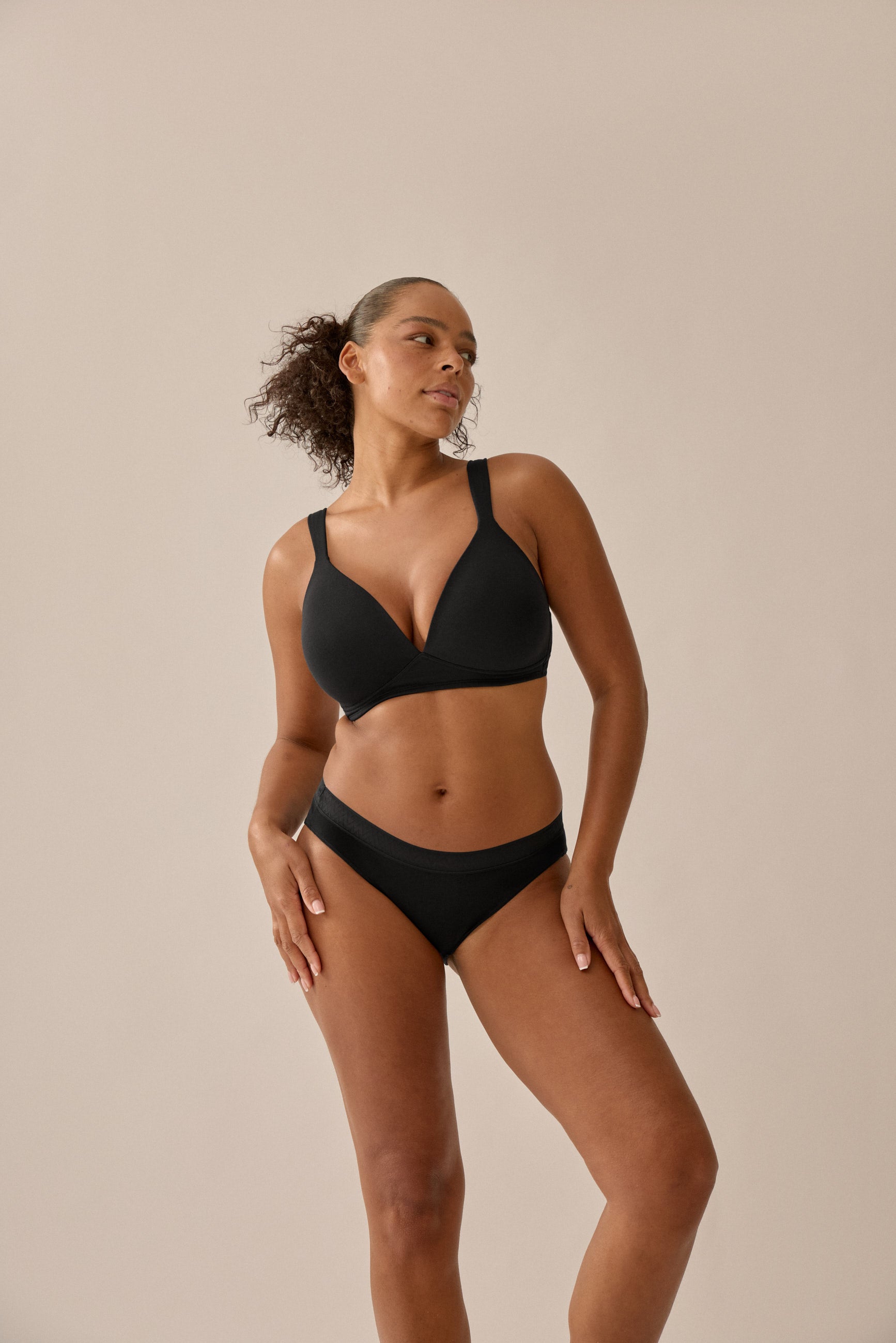 Model wearing Naturana's Cotton moulded cup bra without underwire bra and briefs set in black with an angle from the front