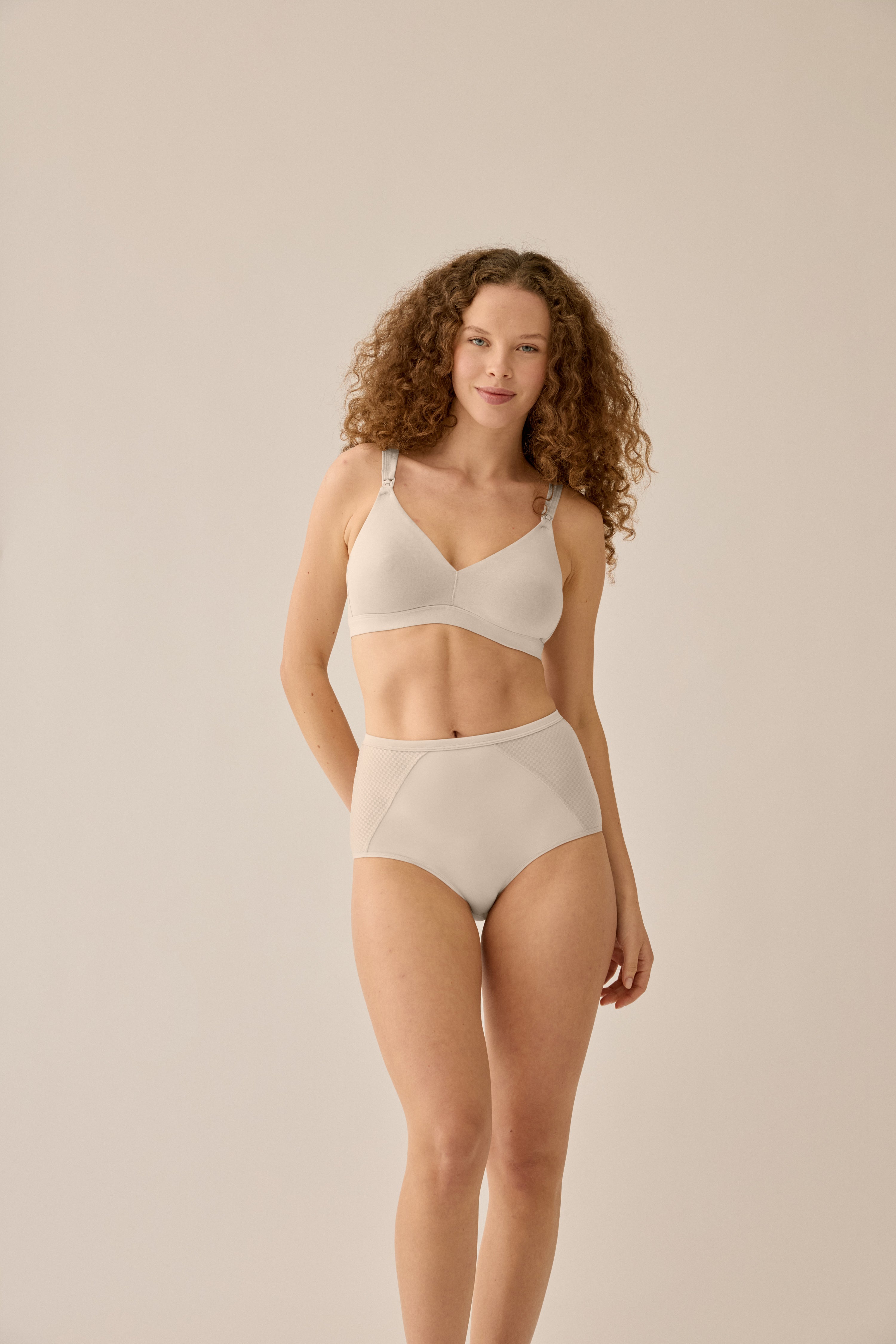 Model steht in NATURANA BH und Taillen Slip in Hautfarben