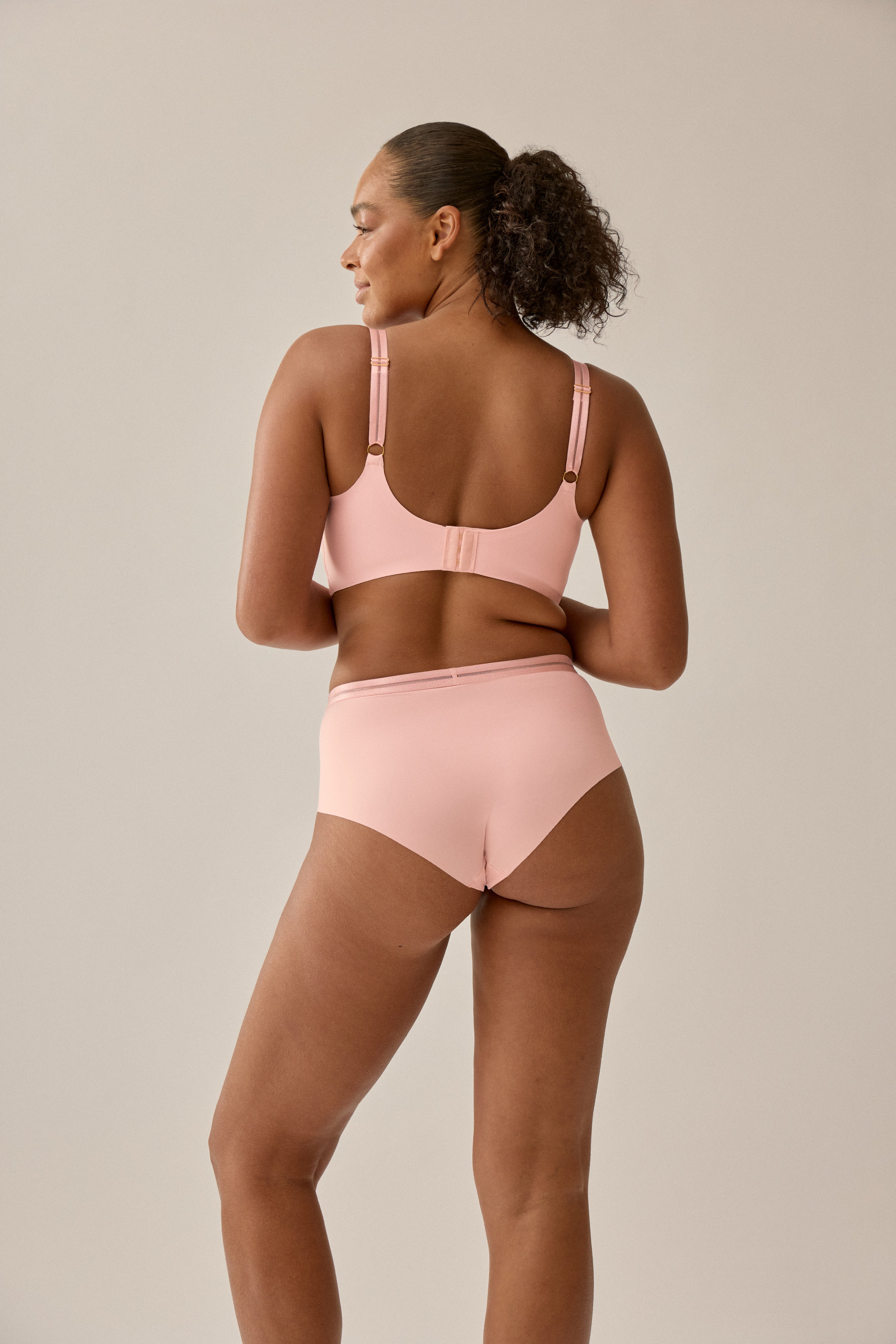 Modell trägt NATURANA BH mit Mesh und softem Tragegefühl in Pink Rose - Rückseite