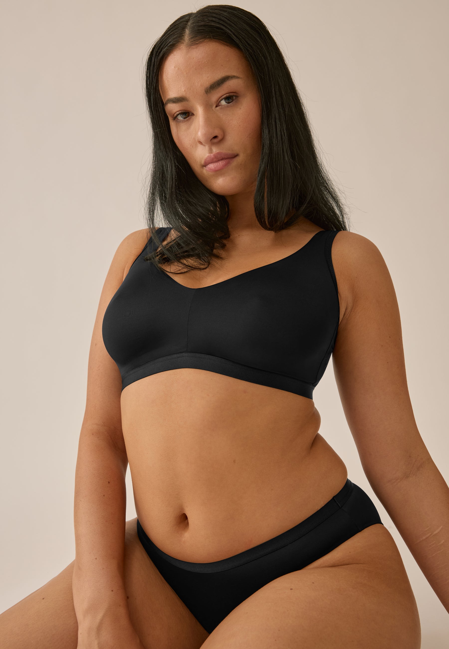 Model trägt NATURANA BH ohne Bügel und Slip in der Farbe schwarz, Vorderansicht
