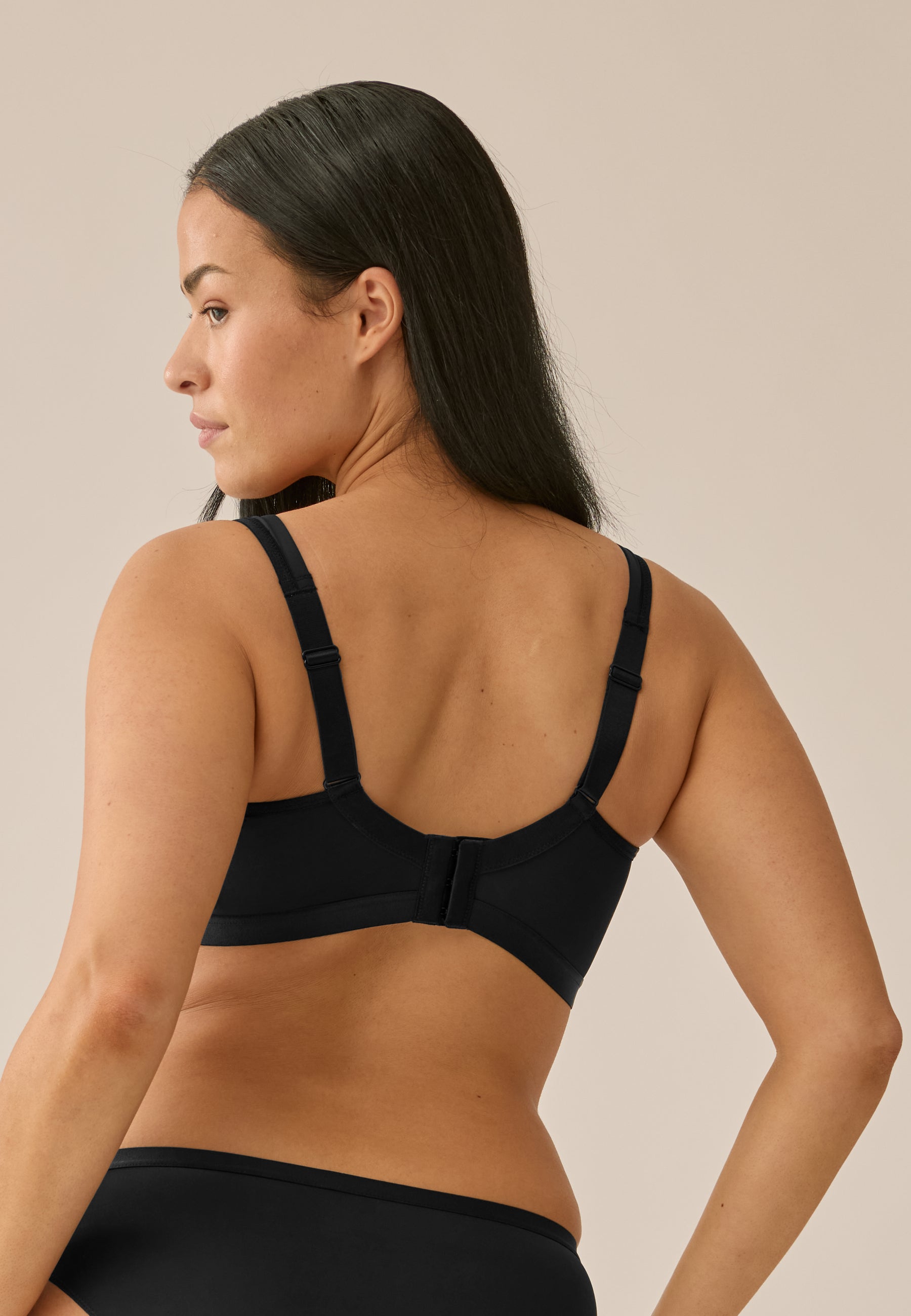 Model trägt NATURANA BH ohne Bügel und Slip in der Farbe schwarz, Rückenansicht