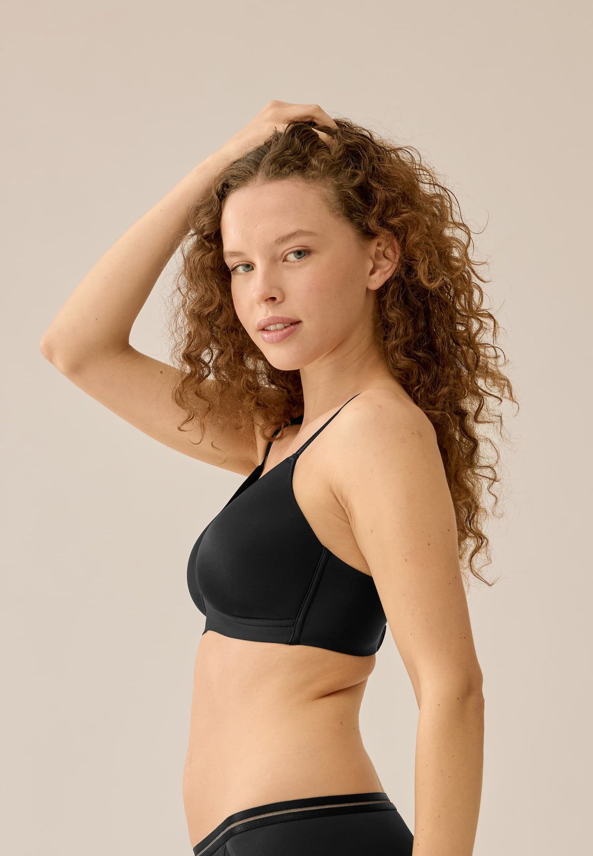 Seitenansicht des bügellosen BHs mit Mesh-Einsatz von NATURANA am Model – Schwarz