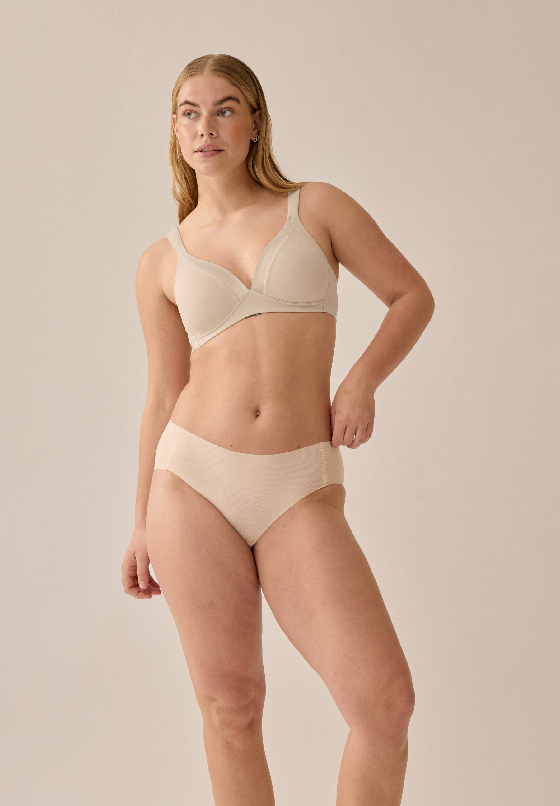 Foto des Models, das den hellbeigefarbenen BH und Slip von Naturana mit Jacquard-Muster trägt, mit Blickwinkel von vorne