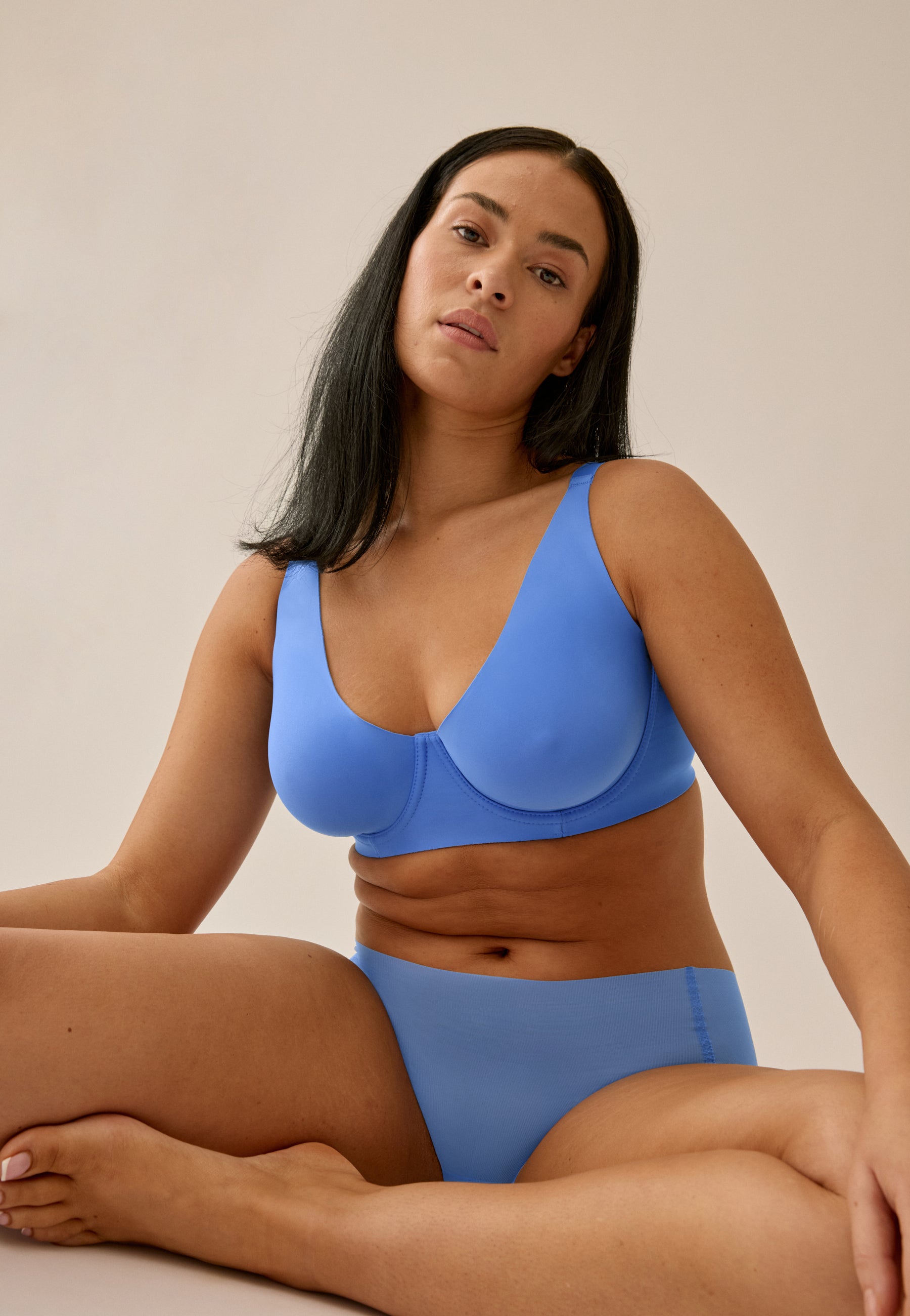 Model sitzend, trägt NATURANA Backsmoother BH mit Bügel und Panty in der Farbe "marina blue"