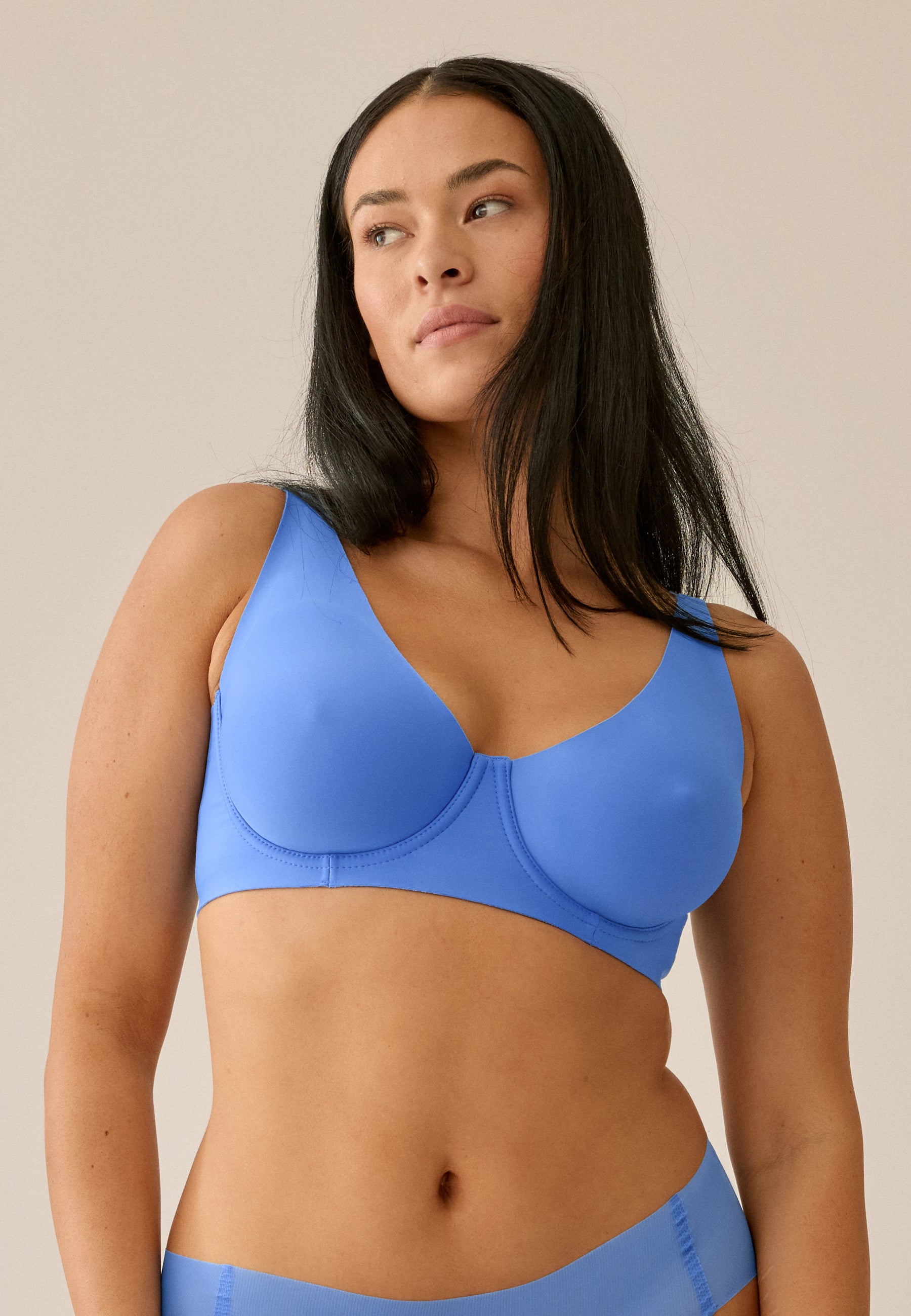 Model steht in Frontansicht, trägt NATURANA Backsmoother BH mit Bügel und Panty in der Farbe "marina blue"