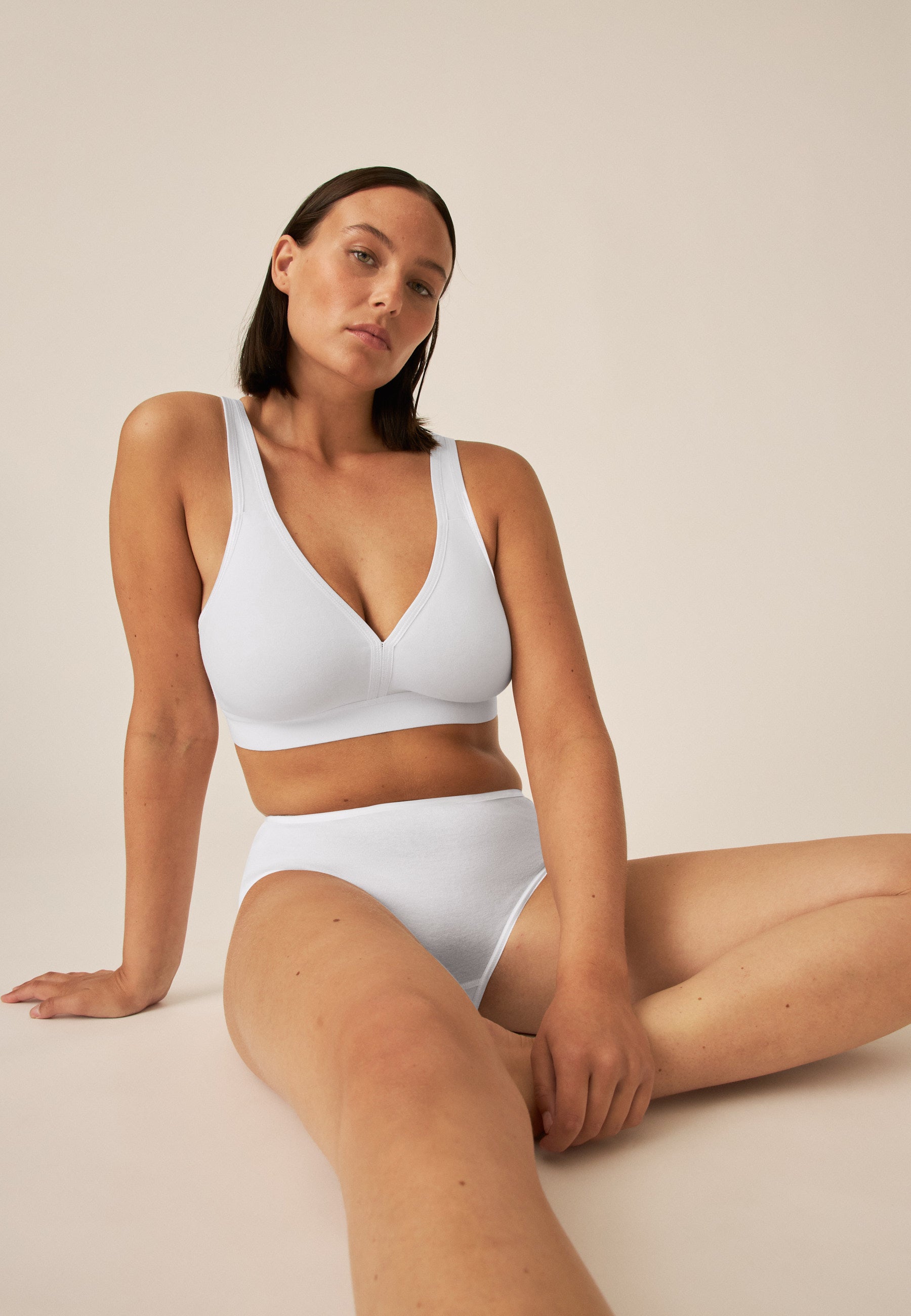 Model posiert im Naturana Athleisure Soft-BH in der Farbe Weiß