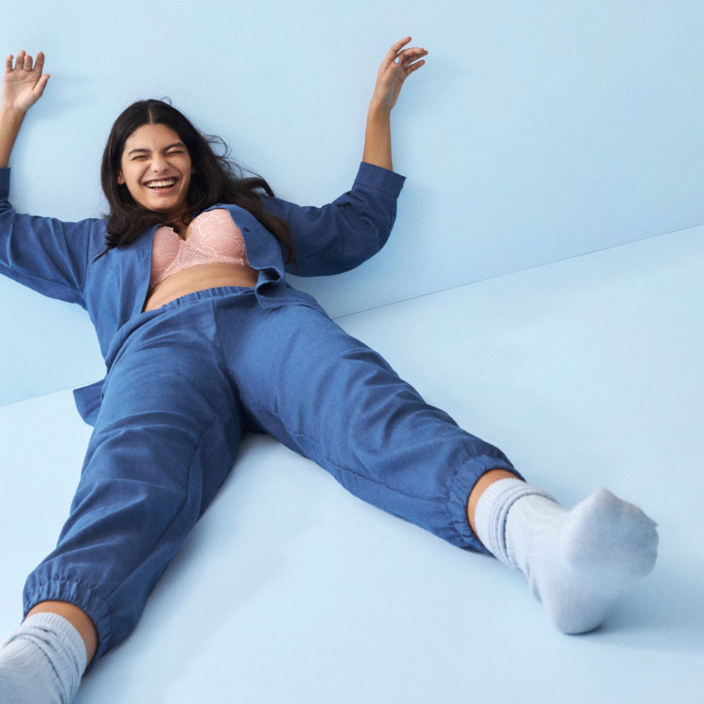 Model liegt im Naturana Oversized Langarmshirt kariert in der Farbe Deep Cobalt Melange