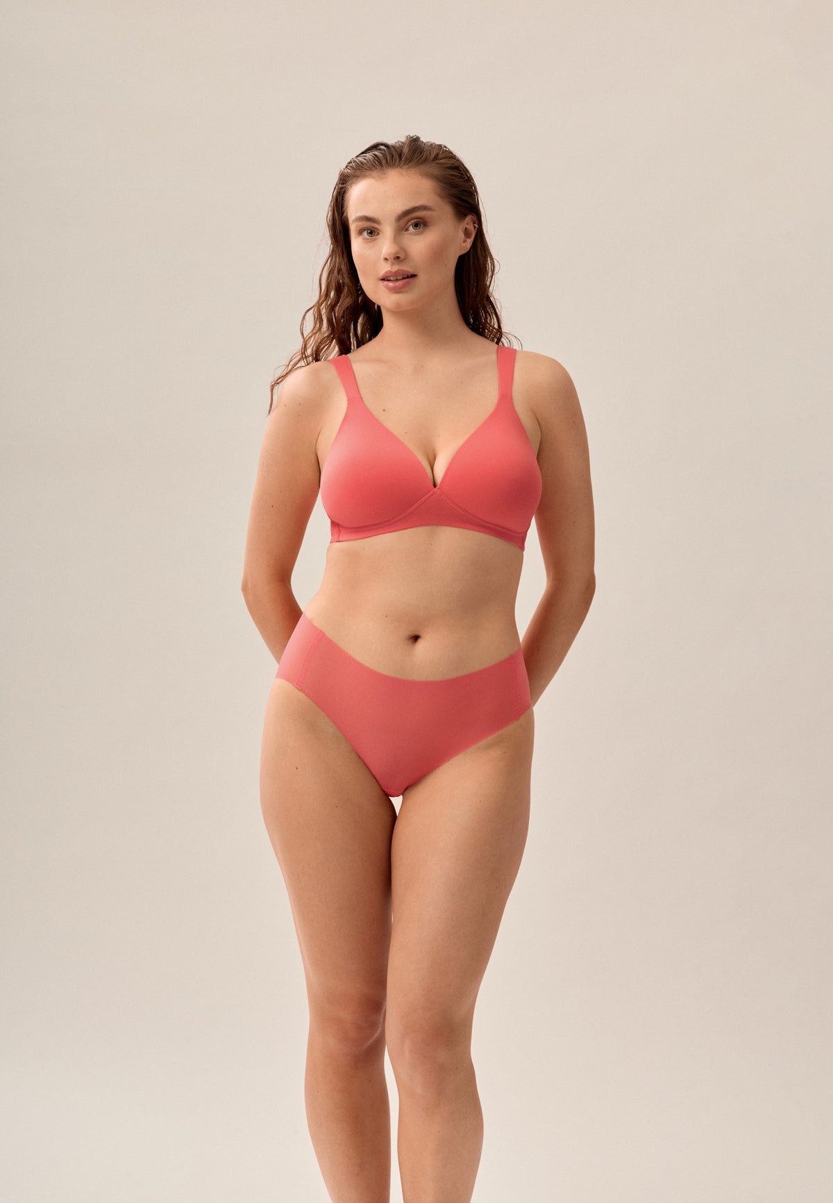 Korallpinke NATURANA One-Size-Panty mit passendem bügellosen Soft-BH, stehendes Model von vorne