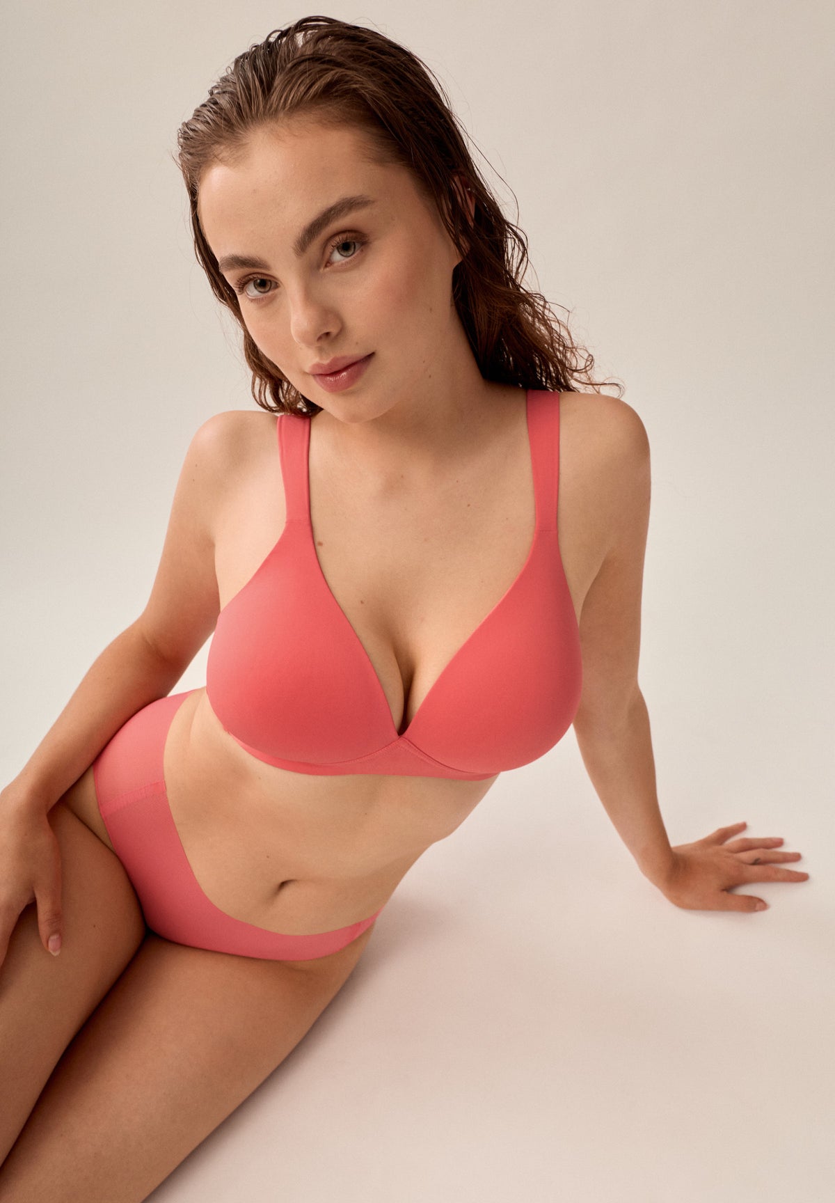 Korallpinker bügelloser NATURANA Soft-BH mit Schale und passender Panty, sitzendes Model von vorne