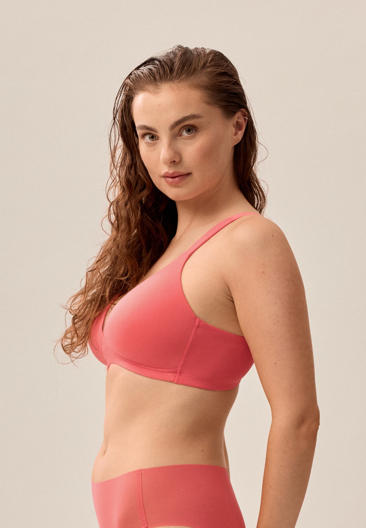 Korallpinker bügelloser NATURANA Soft-BH mit Schale und passender Panty, stehendes Model von der Seite